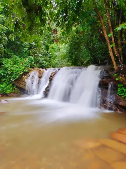A long exposure shot of a beautiful, multi-tiered waterfall in the Nethravathi region.