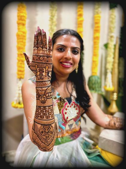 A happy client showing off her full arm mehndi. The design is a beautiful mix of geometric patterns and personalized initials.