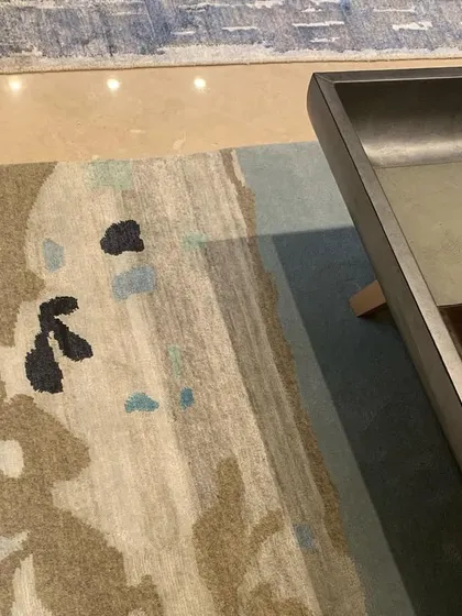 A detail of the abstract-patterned rug, showing how its colors tie together the different elements of the room.