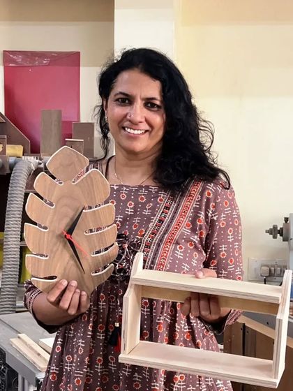 Madhumati with the leaf-shaped clock and small shelf she created during a Basic Carpentry Workshop. She's already a creator and came to learn some new skills.