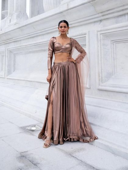 A full-length shot of our metallic bronze lehenga with a slit. This is a celebrity-style look you can actually wear.