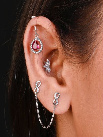 A bold and romantic stack, with a ruby-red teardrop hanging from the helix and an infinity-themed chained stud.