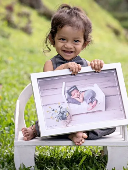 A recap of this little one's growth story. Holding his newborn picture at his one-year session shows just how much they change.