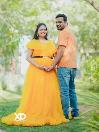 A classic, smiling couple's portrait in a beautiful, sunny garden setting.