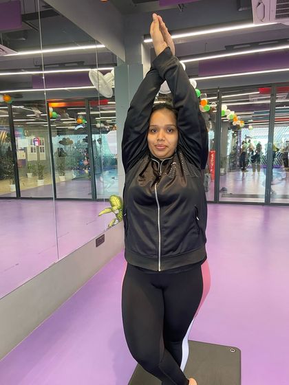 This member holds a variation of the Eagle Pose, showing the strength and flexibility gained through consistent yoga practice.