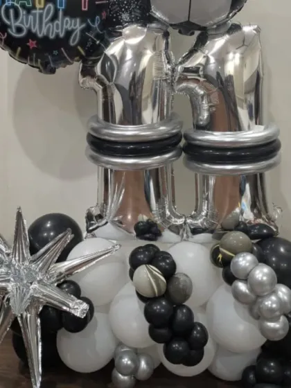 The base of the football-themed balloon column, with black, white, and silver balloons creating a stylish look.