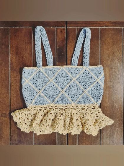 Here is the granny peplum top laid flat. The combination of the structured granny squares and the delicate, lacy peplum creates a beautiful contrast in textures.