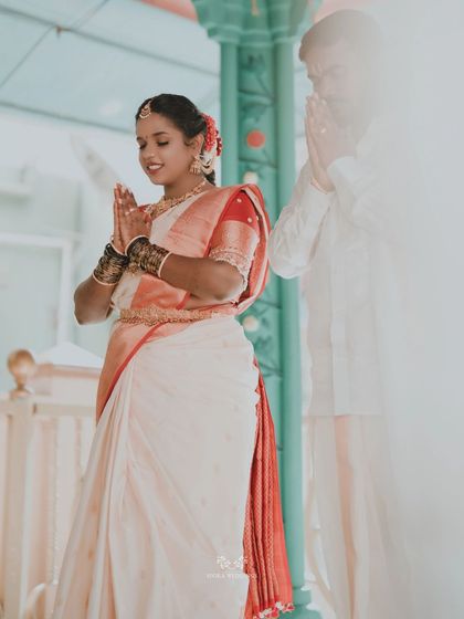 The couple offering prayers together, their hands joined in a gesture of reverence and unity.