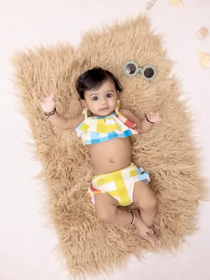Beach baby vibes in the studio. We create fun, imaginative scenes like this overhead shot on a "beach," complete with shells and sunglasses, for a unique and playful baby portrait.