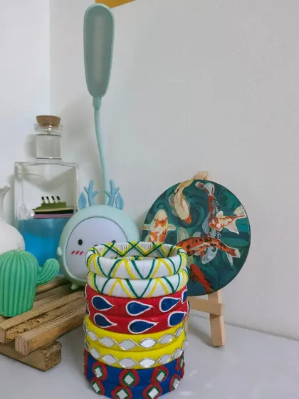 A stack of my colorful handmade bangles, ready for customization. You can see different designs, including thread work, mirror work, and painted patterns, which can be made in any color to match your outfit.