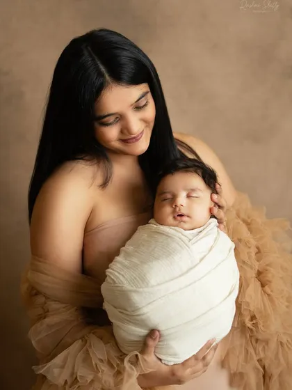 A close up of the mother looking down at her sleeping baby with so much love and adoration.