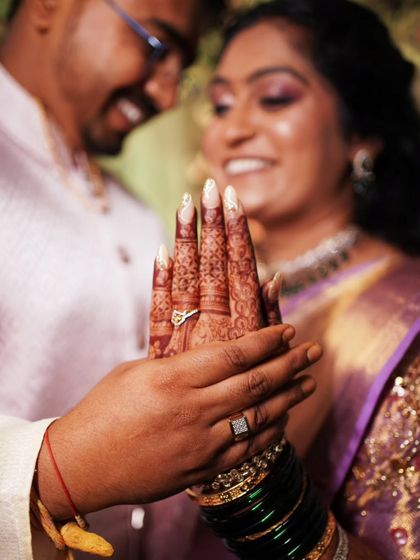 A beautiful shot focusing on the bride's hand, adorned with her engagement ring, held lovingly by her partner.