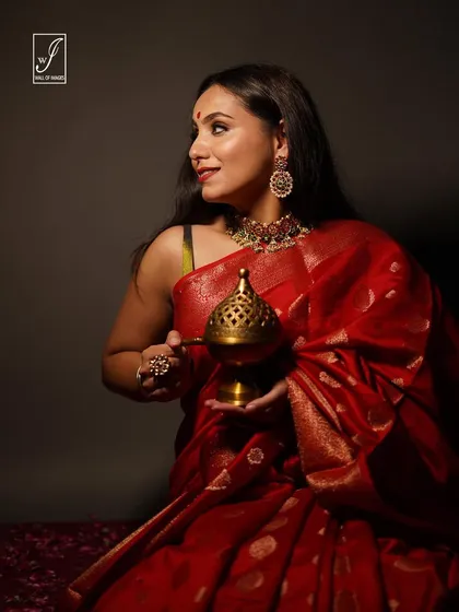 A profile view from the festive saree shoot, highlighting the model's traditional jewelry and the rich color of the fabric.
