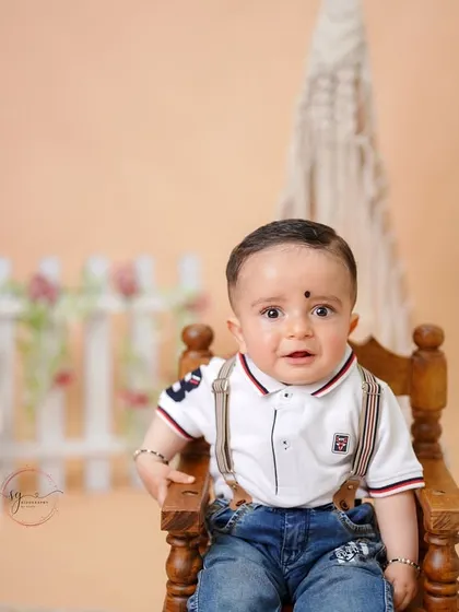 A classic portrait in a miniature wooden chair, this shot captures a curious and wide-eyed look from the birthday boy.