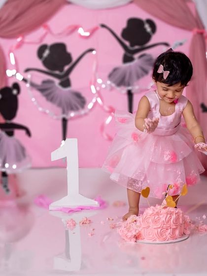 A little ballerina smashes her cake with grace and joy in our adorable ballet-themed setup.