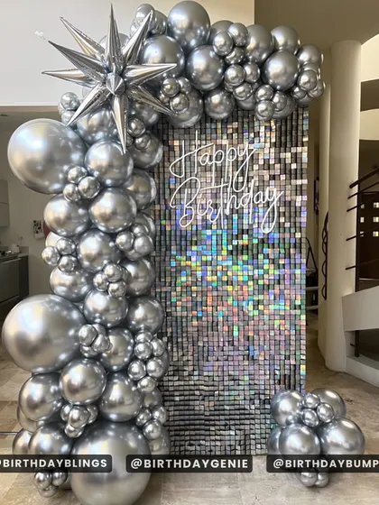 A pure chrome and silver balloon arch against a silver shimmer wall. This monochromatic design is incredibly chic and modern, perfect for a stylish celebration.