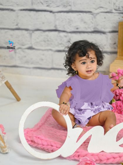 A wide shot of the pink and purple first birthday setup.