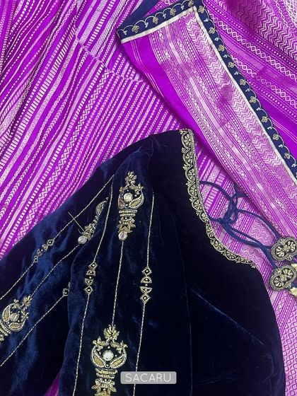 The sapphire blue velvet blouse paired with a contrasting magenta and silver Kanjeevaram saree, a timeless wardrobe combination.