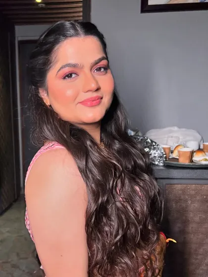My bride Ishita's Sangeet look, featuring bold pink eyeshadow and soft, romantic curls.