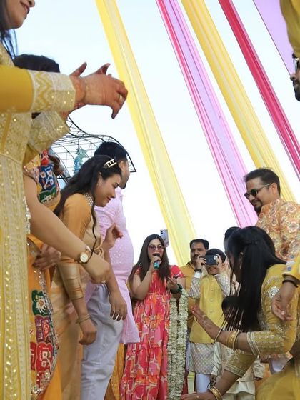 In the midst of the action during a game at a Haldi. I'm not just an anchor on a stage; I'm right there with the guests.
