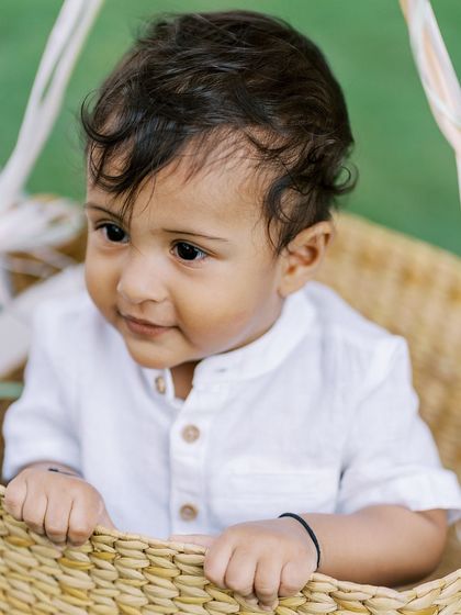 A close-up of a baby boy in a basket, looking thoughtful. These quiet moments are a beautiful contrast to the playful ones.