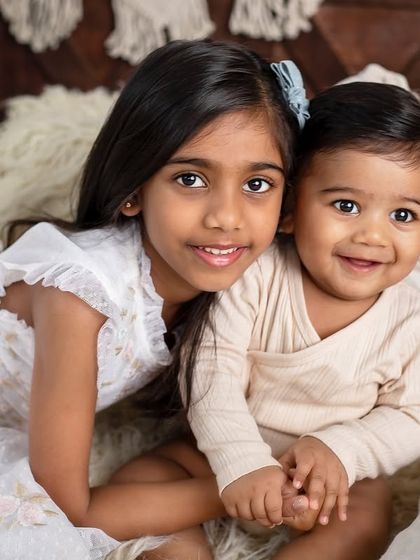 A close-up portrait of this adorable brother and sister duo. Their bright smiles and clear bond make this photo incredibly heartwarming.