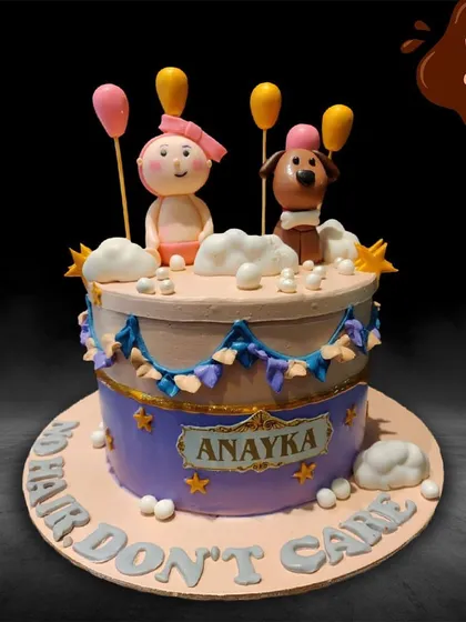 A charming and funny cake with the theme "No Hair, Don't Care." It features cute, handcrafted figures of a baby and a dog, complete with balloon accents, perfect for a lighthearted celebration.