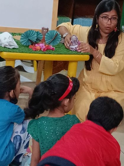 The storyteller shows the children the props up close, allowing for a tactile connection to the story.