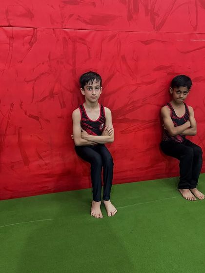 Discipline is a mindset. Here, my students are doing a wall sit with arms crossed, an exercise that builds isometric leg strength and mental toughness.