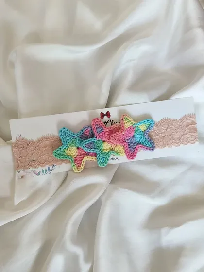 Twinkle twinkle! This newborn headband features three pastel rainbow crochet stars on a soft, lacy band. It's delicate, adorable, and affordable.