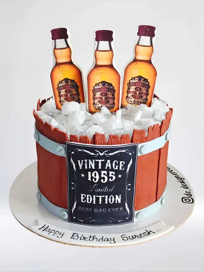 A Chivas Regal-themed barrel cake for a 70th birthday. This "Vintage 1955" cake is designed to look like a wooden barrel filled with ice and whiskey bottles.