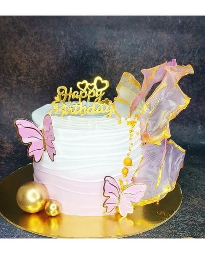 A beautiful cake featuring delicate, edible rice paper sails. This fresh strawberry vanilla cake is decorated with pink butterflies for an artistic and modern look.