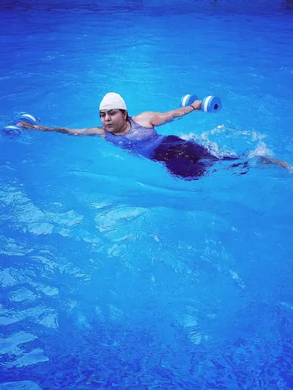 This image captures a dynamic movement, showing how we combine floating with resistance training for a comprehensive, full-body workout in the water.