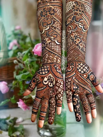 Another angle of this gorgeous bridal design, showing how the patterns wrap around the hands. The initials 'AR' are the centerpiece of this personalized mehendi.