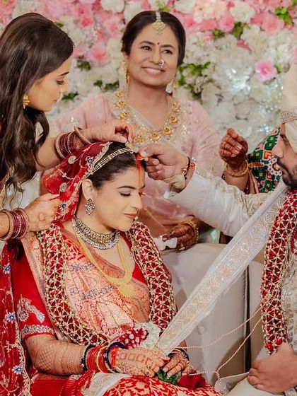 Surrounded by family, the couple shares a quiet moment during the sindoor ceremony. We manage the event flow so our couples can be fully present for these important traditions.