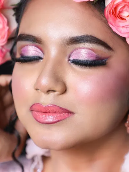 A detailed close-up of the eye makeup. The shimmery pink shadow and long lashes create a look that is both gentle and glamorous.
