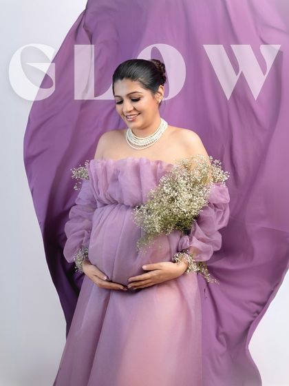 Glowing from within. The "GLOW" text overlay perfectly describes the radiant mother-to-be in this beautiful lavender-themed portrait.