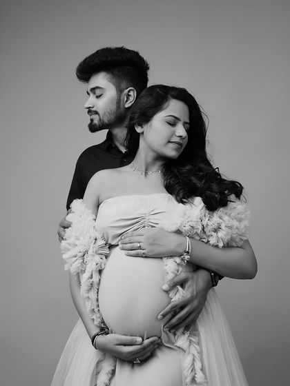 A beautiful black and white portrait of a couple. The focus is on the emotional connection and the beautiful silhouette of the baby bump.