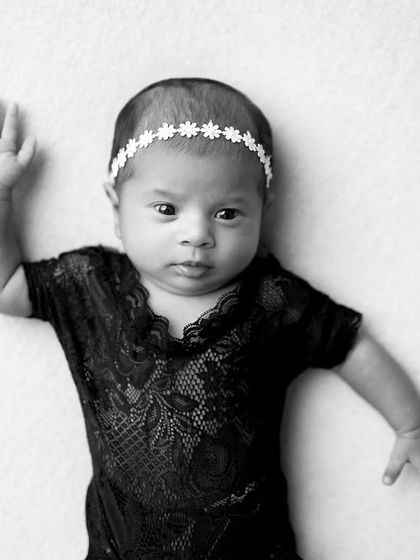 A calm, awake moment. This baby looks like she's waving hello in this simple and sweet black and white portrait.
