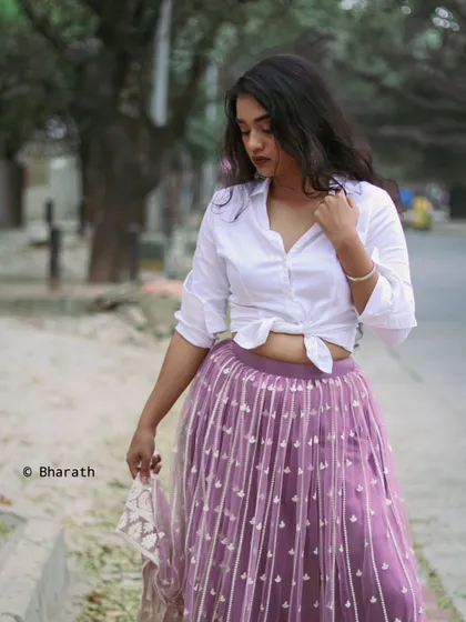 A walking shot that captures the movement of the skirt and the casual elegance of the overall look. This is great for showing how the outfit moves and feels.