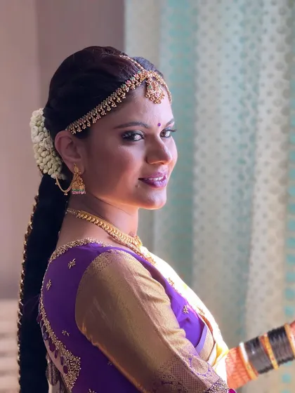 A beautiful profile shot, capturing the bride's elegant hairstyle and the glow of her makeup in the natural light.