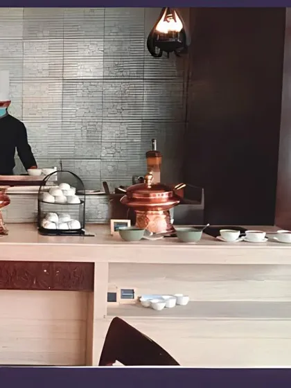 A chef at an indoor live station, ensuring all hygiene standards are met while preparing fresh food for guests. This setup is perfect for office lunch catering and seminars.