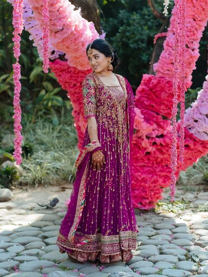 A bride in a vibrant magenta Anarkali, her effortless radiance shining through in a beautiful garden setting at Taj Corbett.