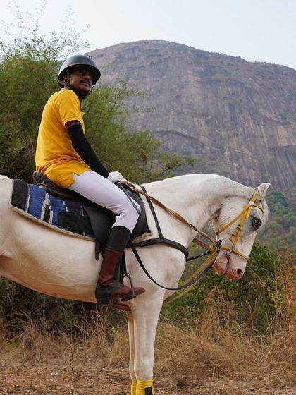 Another happy rider on a white horse, with a massive rock formation behind him. The landscapes on our safari routes are simply breathtaking.