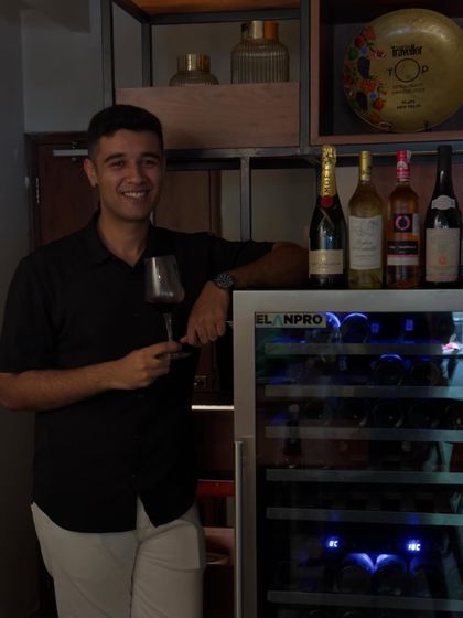 Our sommelier Udiksh standing by the wine cooler where we store our curated collection. His expertise ensures every bottle, from Moët to lesser-known gems, is ready for you to enjoy by the glass.