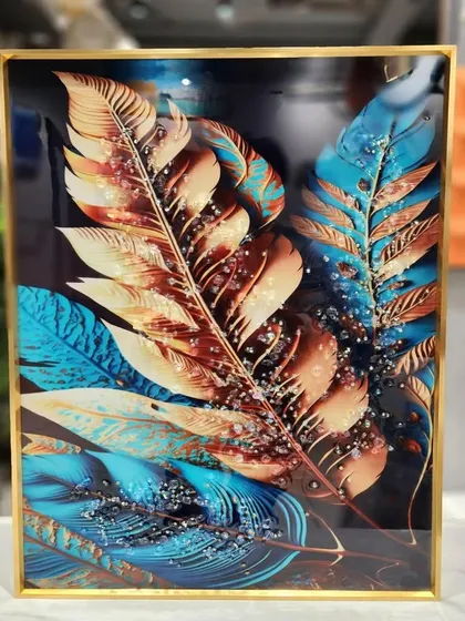 This vibrant crystal painting features a collection of shimmering feathers in shades of blue and bronze. The rich colors and sparkling details make this 16x24 inch piece a truly eye-catching work of art.
