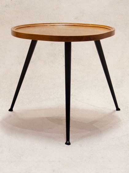 Another view of the 'Tipoy' side table, showcasing its clean design. The raised edge of the teak top is a practical detail to keep items secure.