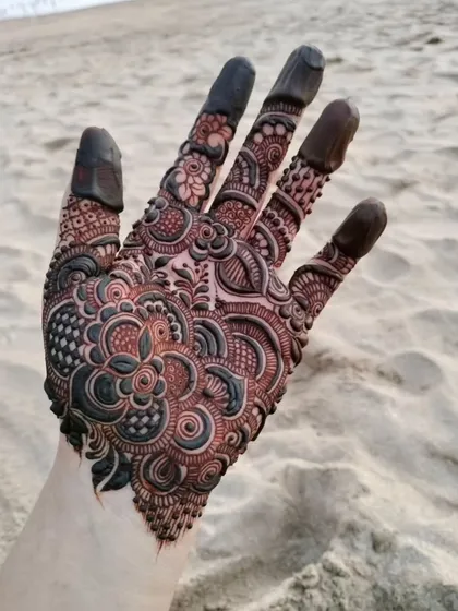 The same intricate beach design, showing the incredible detail on the palm and fingers.