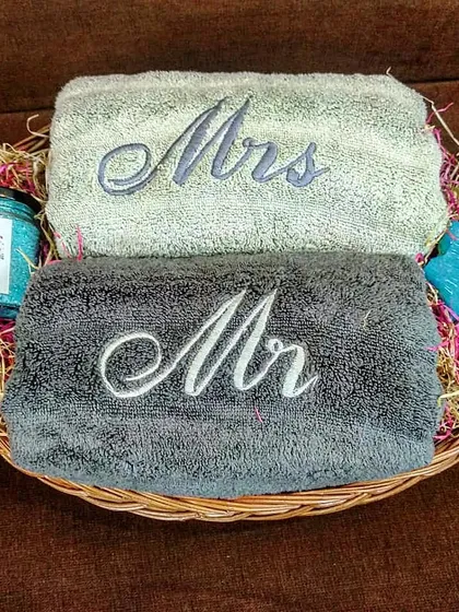For a more minimalist option, this couple's hamper is perfect. It features 'Mr' and 'Mrs' embroidered hand towels in contrasting colors, paired with bath salts and a shaped soap in a simple basket.