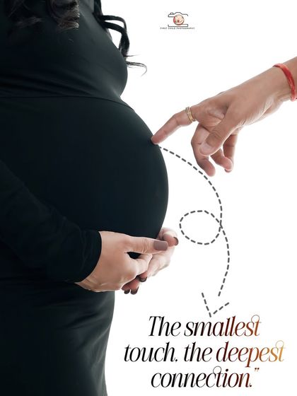 A creative and symbolic close-up. The partner's finger gently touches the baby bump, with text that reads 'The smallest touch, the deepest connection'.